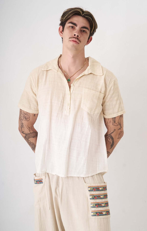 Minimalist pastel cream shirt with asymmetrical buttons and oversized fit for sustainable fashion.